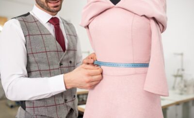 Hands of male fashion designer measuring waist