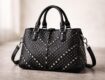 découvrez le sac à main noir clouté, l'accessoire chic et tendance qui apporte une touche d'originalité affirmée à votre style.